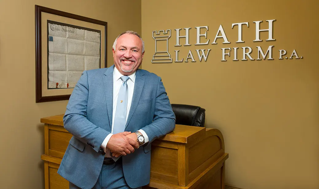 Image of James Heath in front of Heath Law signage on wall.